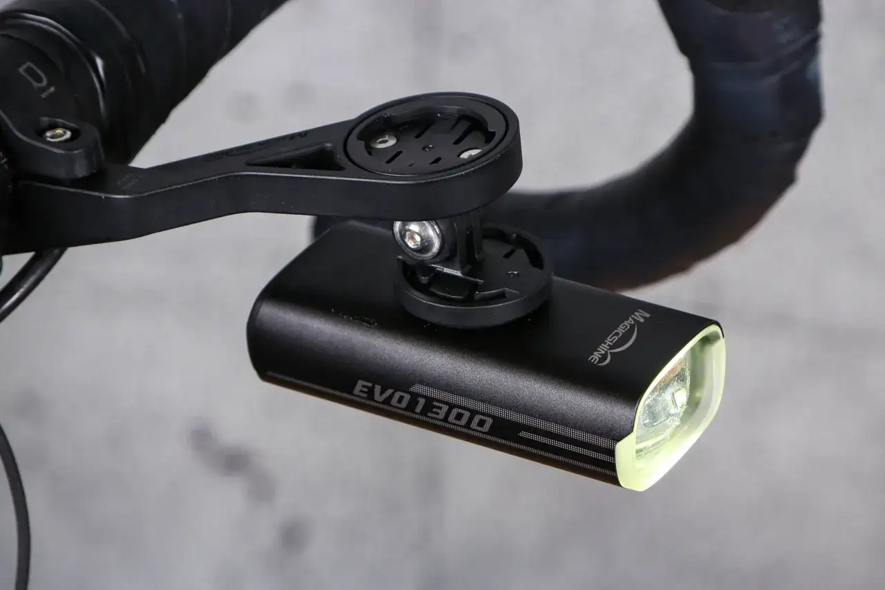Mocna lampka rowerowa Magicshine EVO 1300 zamontowana na kierownicy, gotowa na nocne wyprawy.