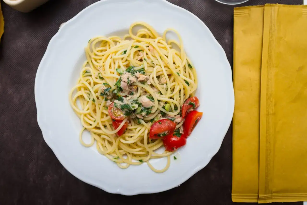 Pyszne danie z makaronem vermicelli lub capellini, z kawałkami ryby, pomidorkami i ziołami.