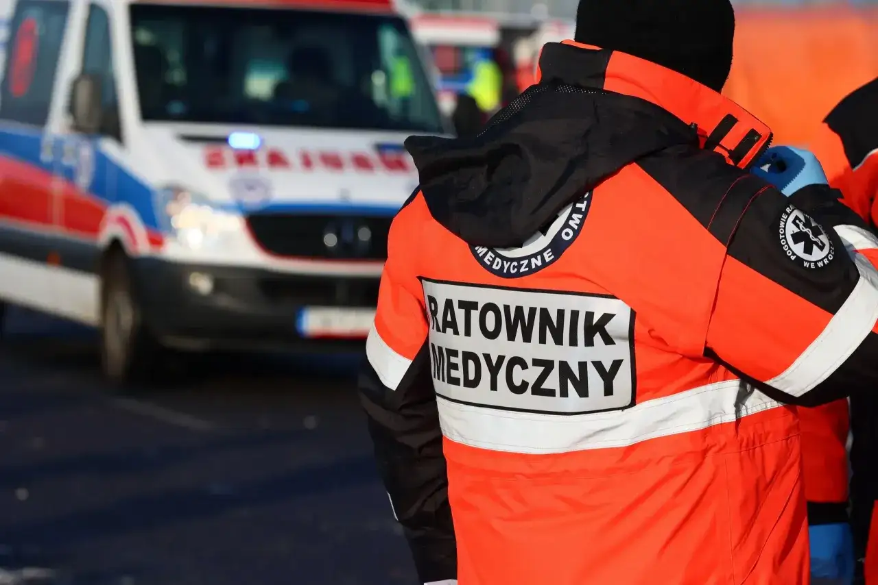 Ratownik medyczny w pomarańczowej kurtce z napisem 