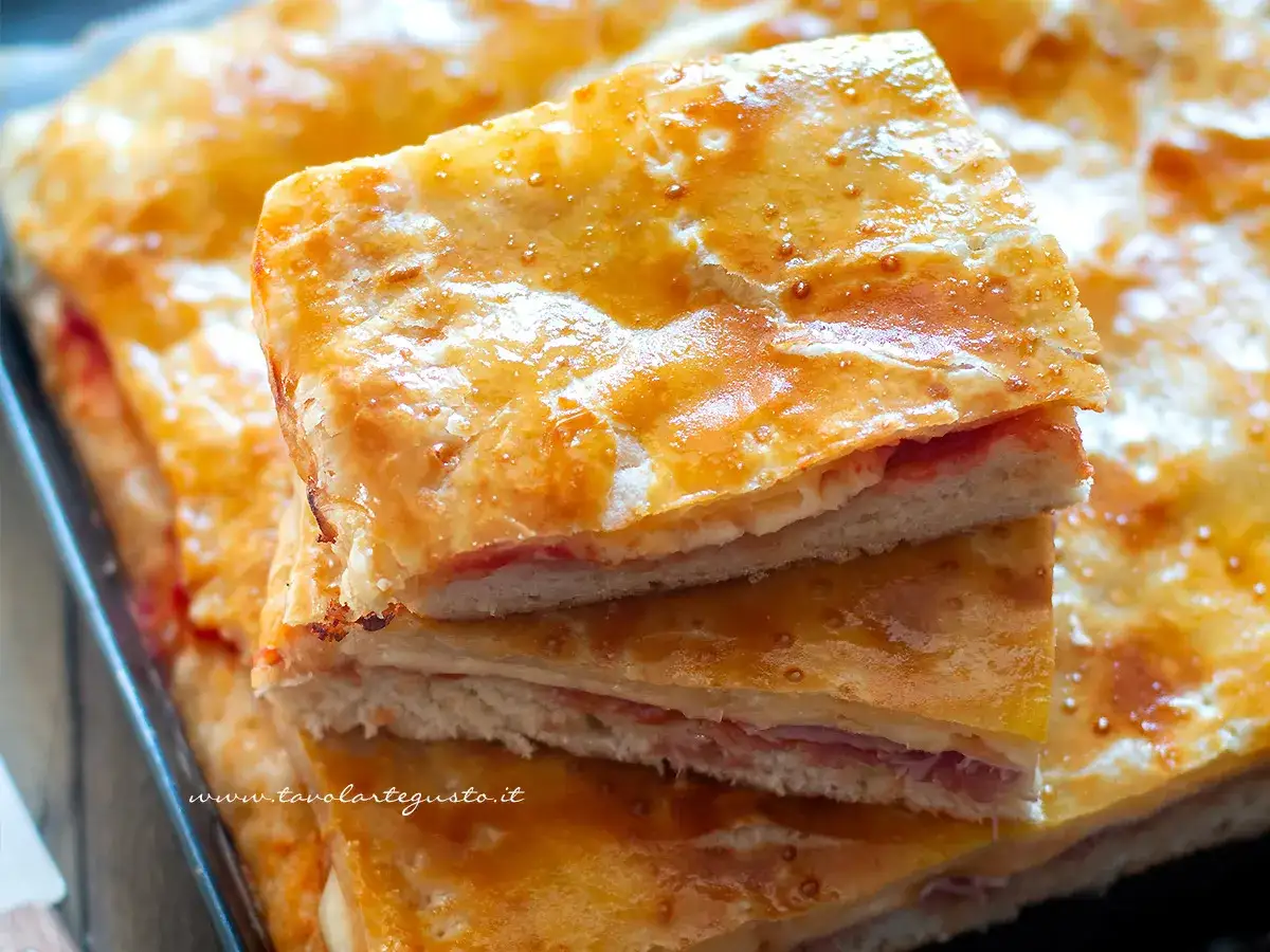 Fette di pane fatto in casa, dorato e fragrante, farcito con prosciutto e formaggio. Un sapore autentico da gustare.