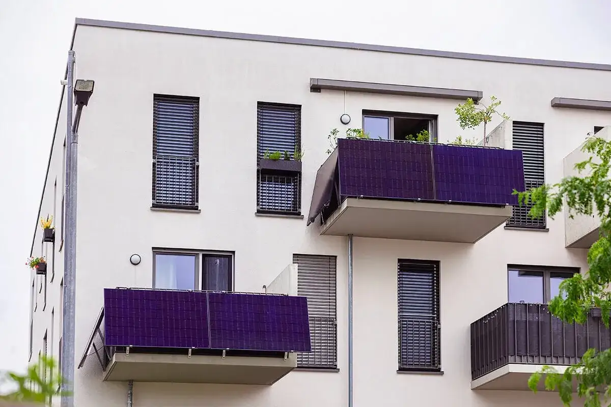 Balcons &eacute;quip&eacute;s de panneaux solaires plug and play. Avis positifs sur cette installation moderne sur un immeuble blanc.