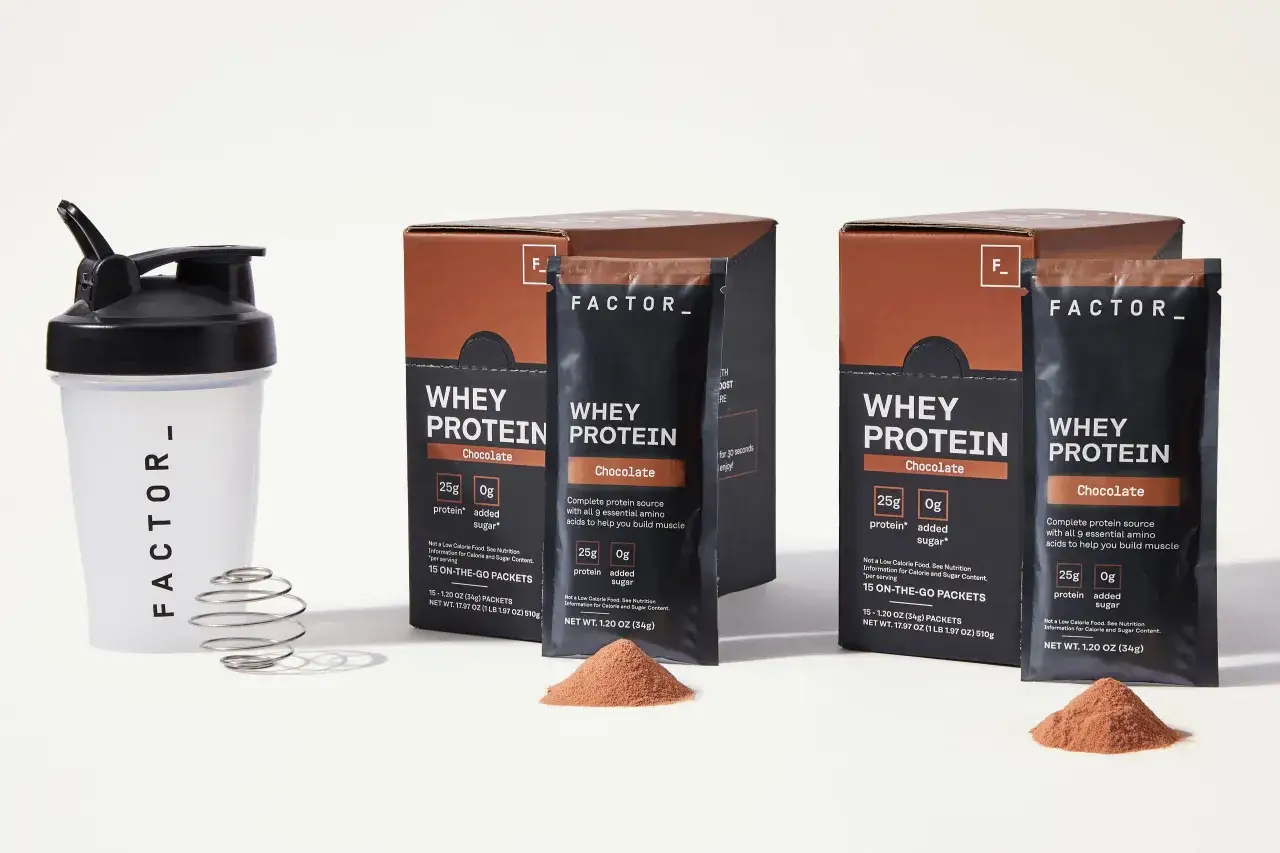 FACTOR_ Shaker mit Schneebesen und Schokoladen-Whey-Protein-P&auml;ckchen. Ideal f&uuml;r unterwegs, um den Muskelaufbau zu unterst&uuml;tzen.
