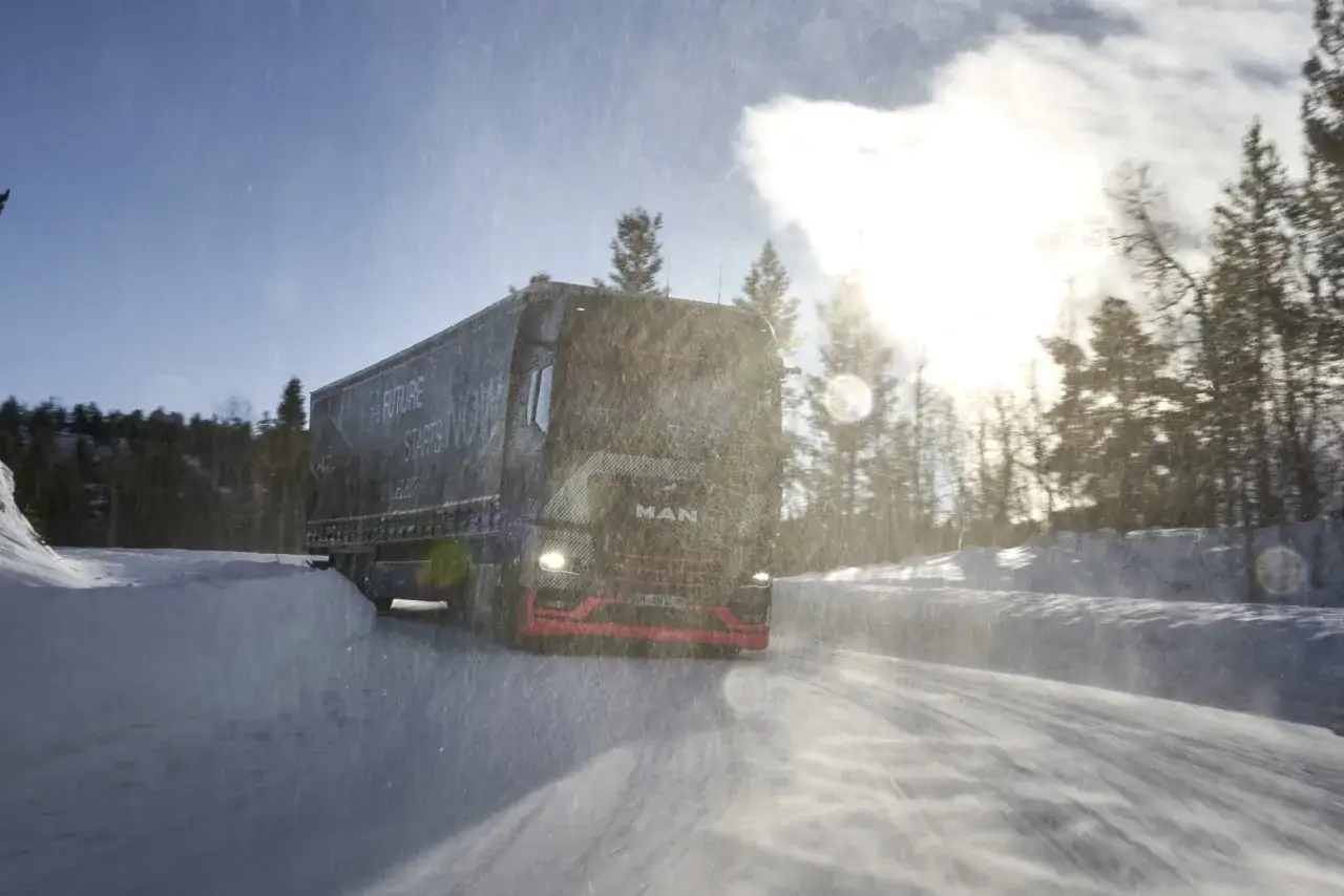 Ein MAN-LKW f&auml;hrt auf einer verschneiten Stra&szlig;e in Schweden. Das 