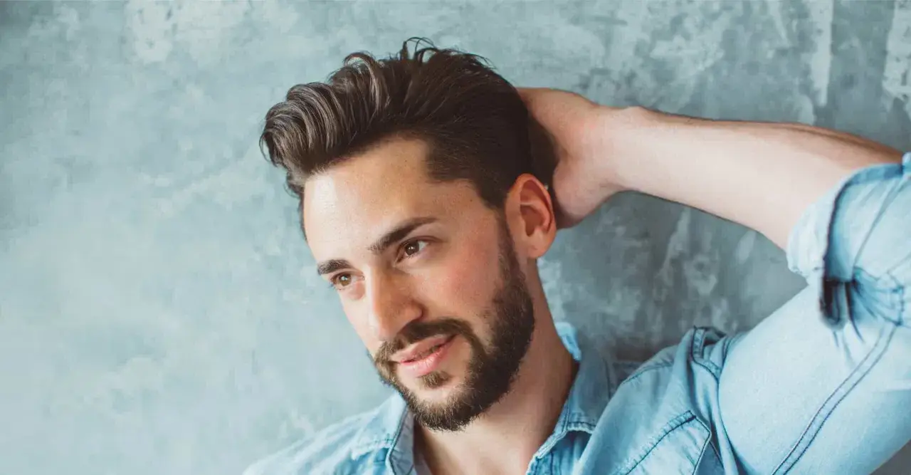 Mann mit vollem Haar, gestylt mit pomade wasserbasiert, l&auml;ssig im Jeanshemd.
