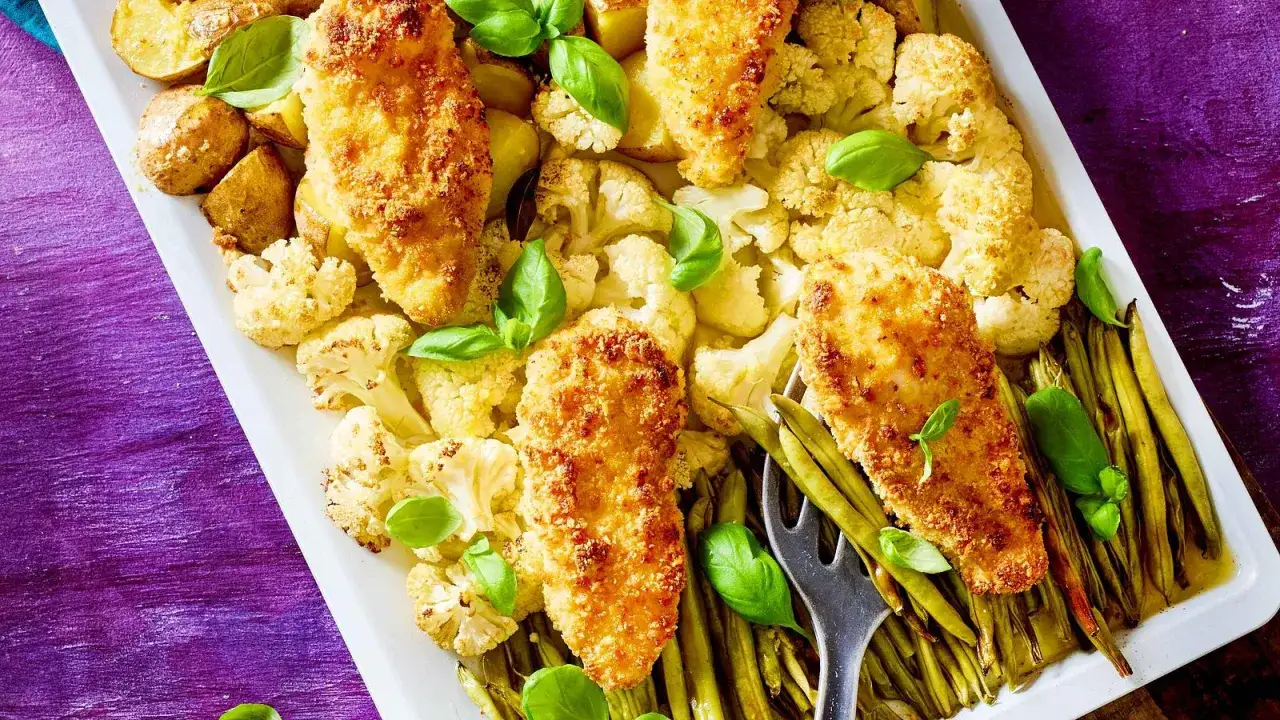 Knusprige Hähnchenbrust mit Blumenkohl, Kartoffeln und grünen Bohnen, garniert mit Basilikum. Perfekt für leckere Rezepte mit Parmesan.