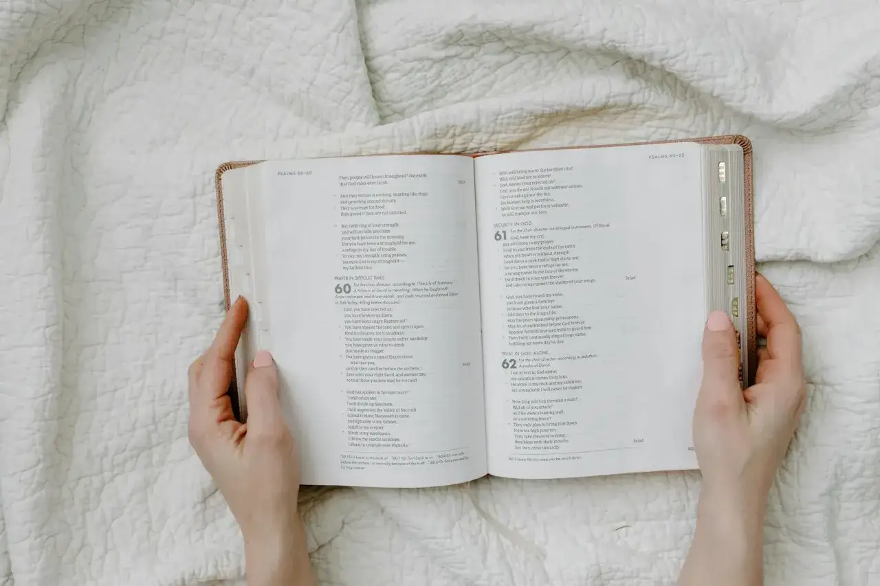 Ręce trzymają otwartą Biblię, szukając odpowiedzi, jak interpretować trudne fragmenty Starego Testamentu o przemocy.