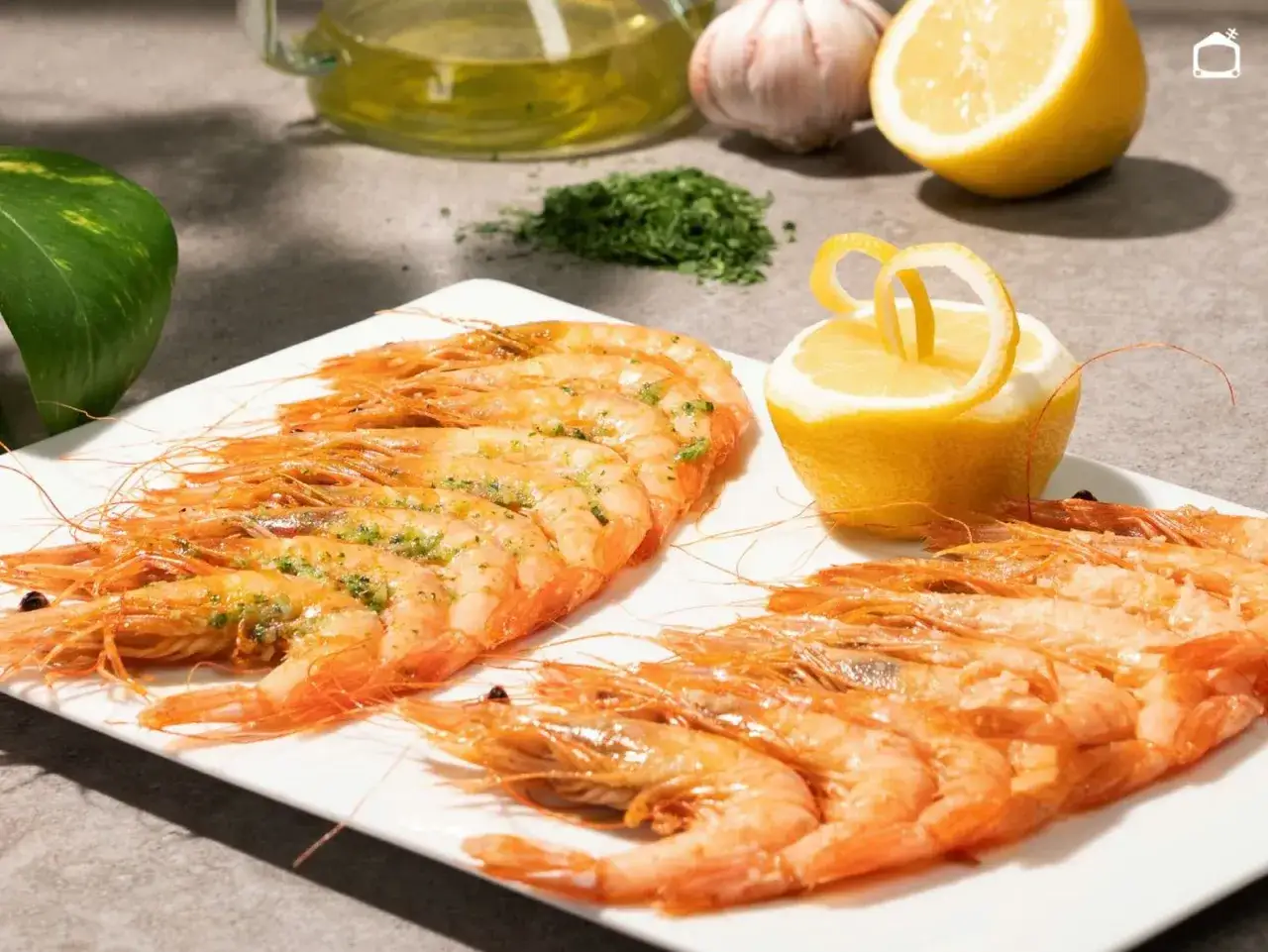 Deliciosas gambas a la plancha, servidas en plato blanco con limón y perejil picado.