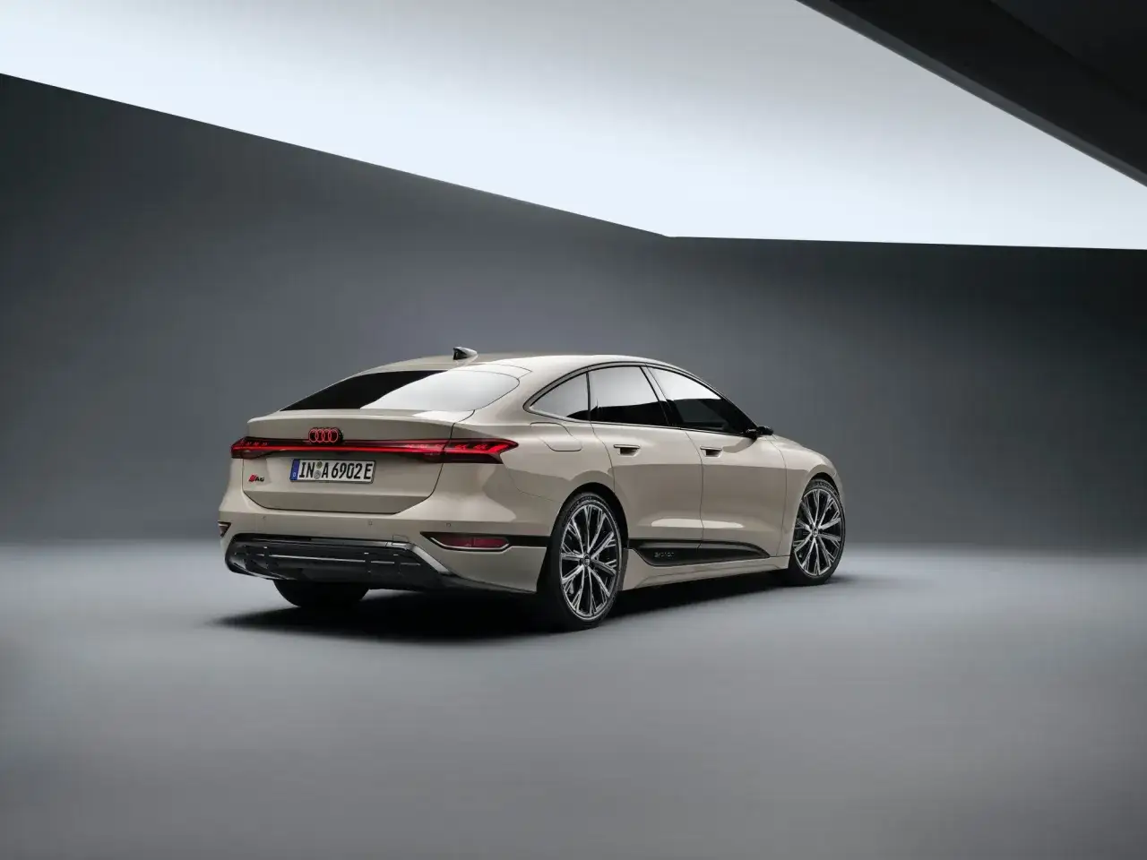 Eleganckie, nowe Audi A6 w kolorze piaskowym prezentuje się z tyłu, podkreślając sportowy charakter i nowoczesny design.