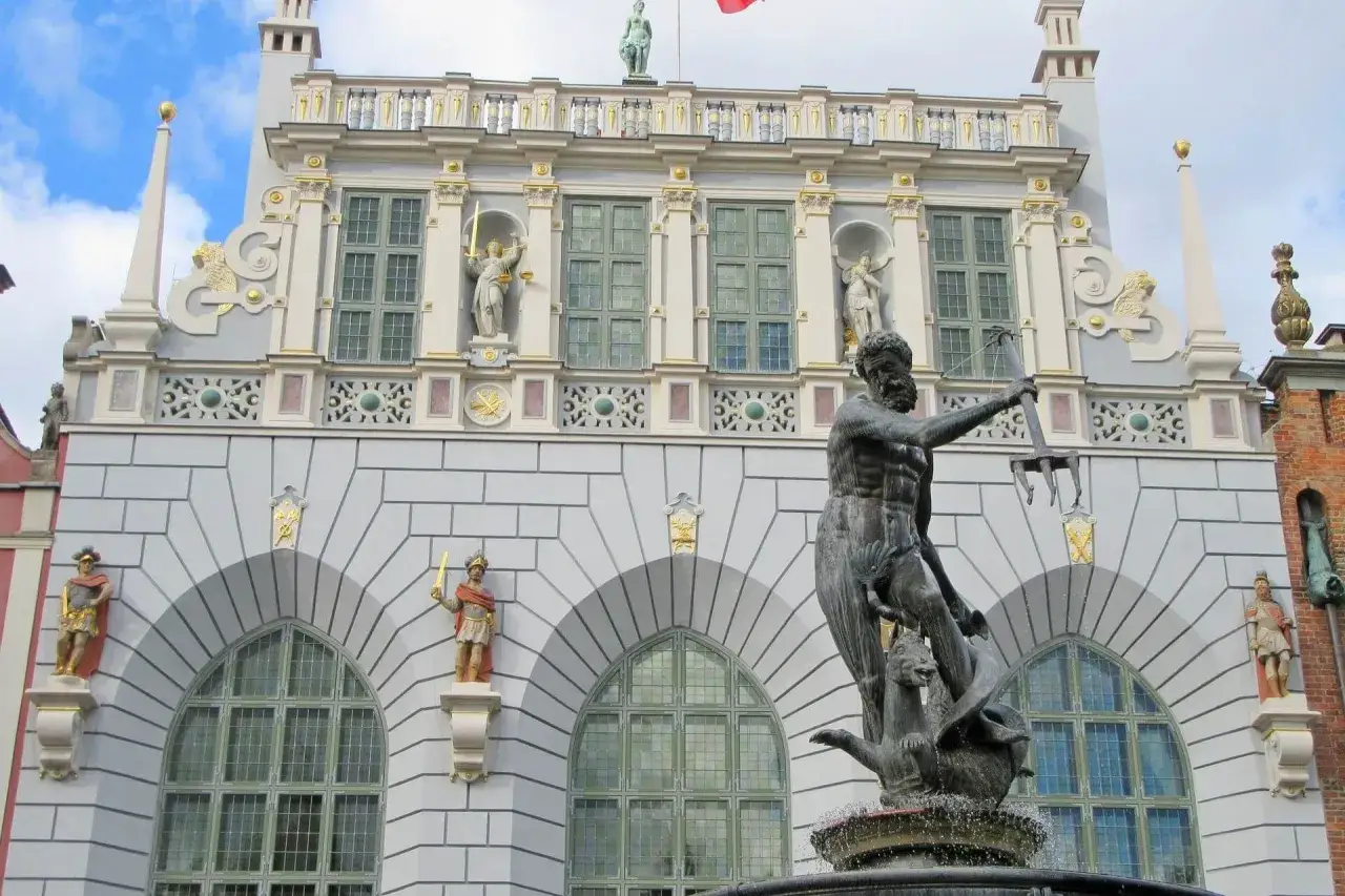 Fontanna Neptuna, symbol Gdańska, ożywia legendy gdańskie. W tle majestatyczna fasada Dworu Artusa.