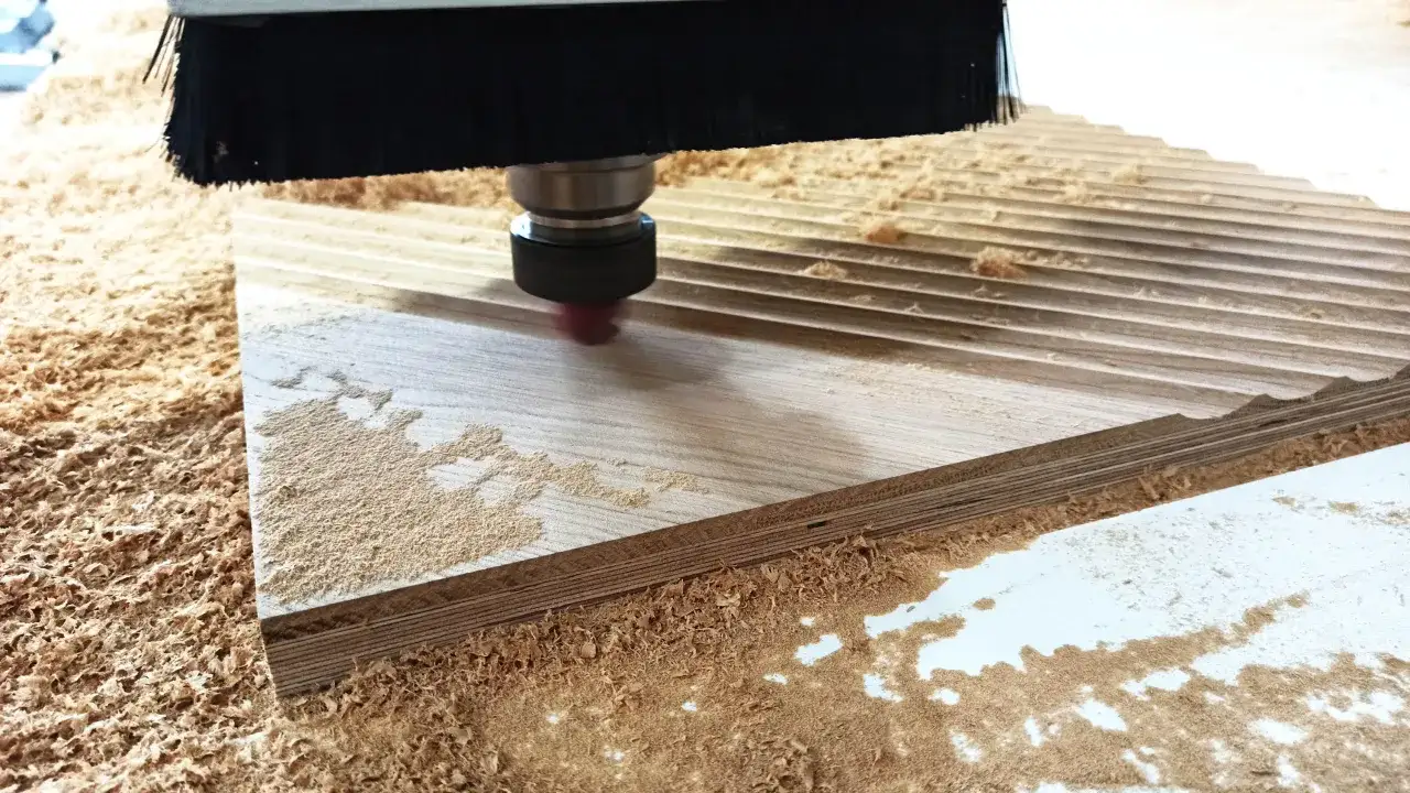 Frez CNC precyzyjnie obrabia drewno, tworząc rowki i usuwając wióry.