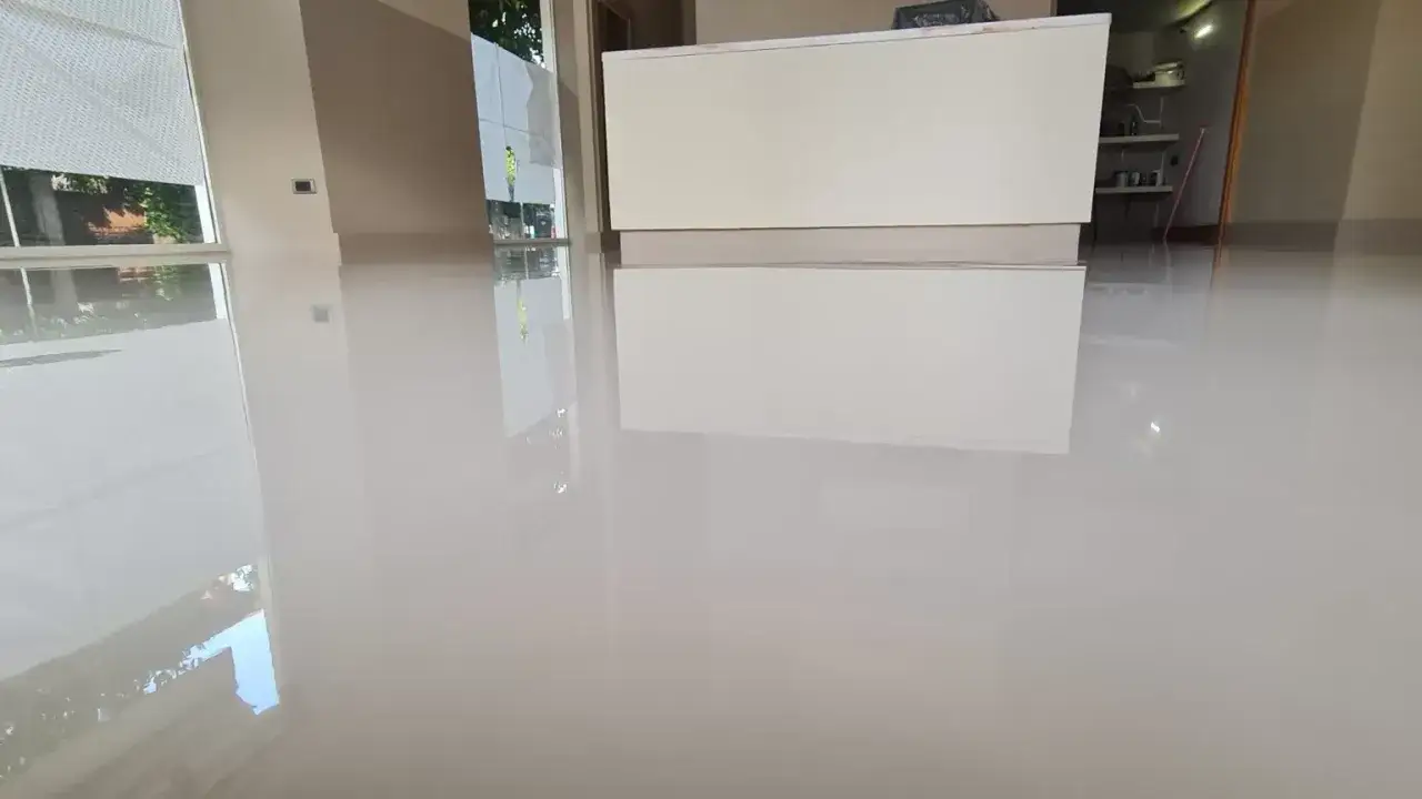 Pavimento lucido e riflettente, appena posato. Il tempo indurimento resina epossidica è quasi completato, creando una superficie impeccabile.