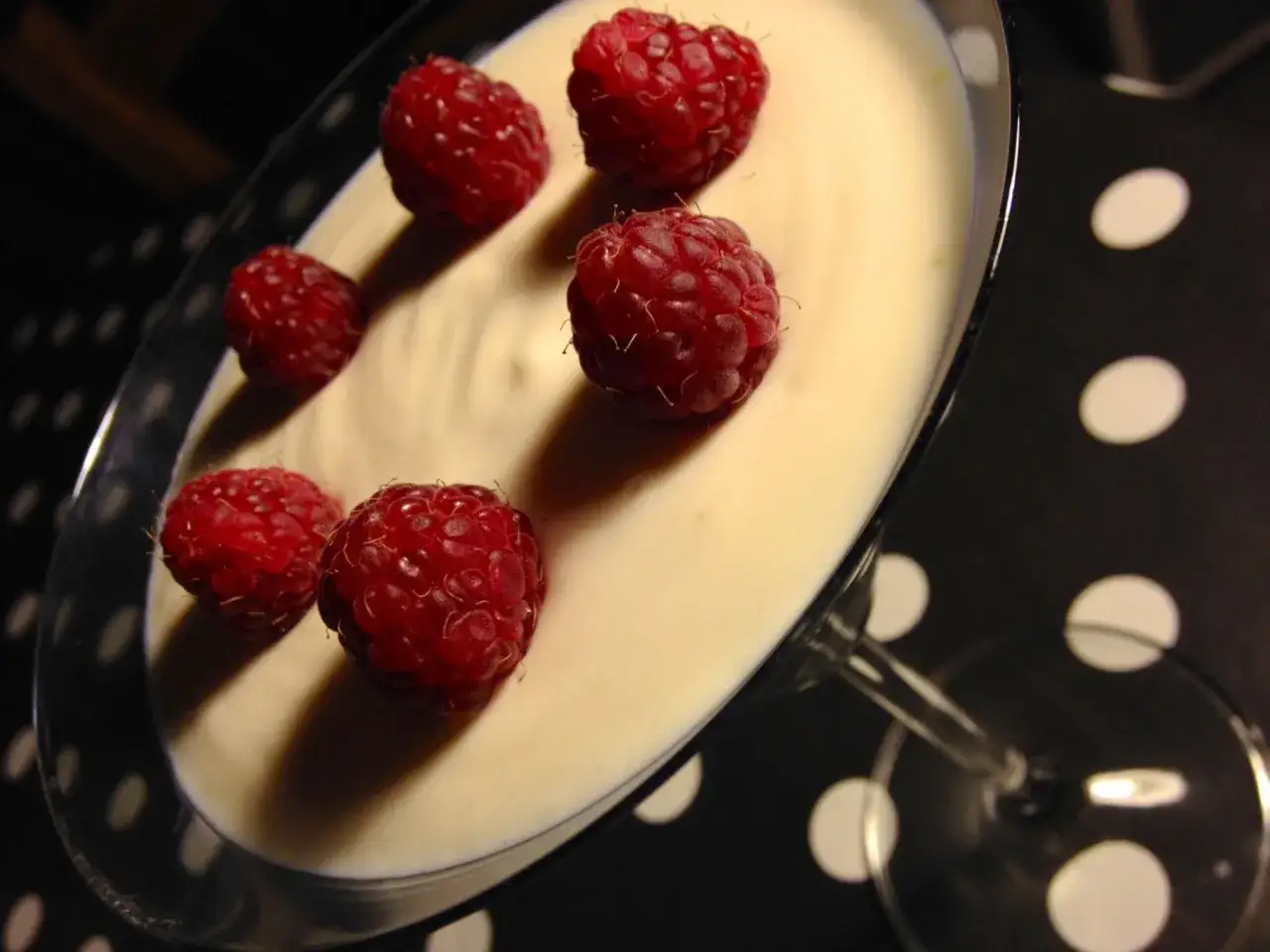 Délicieuse mousse ricotta citron garnie de framboises fraîches, servie dans un verre à cocktail.