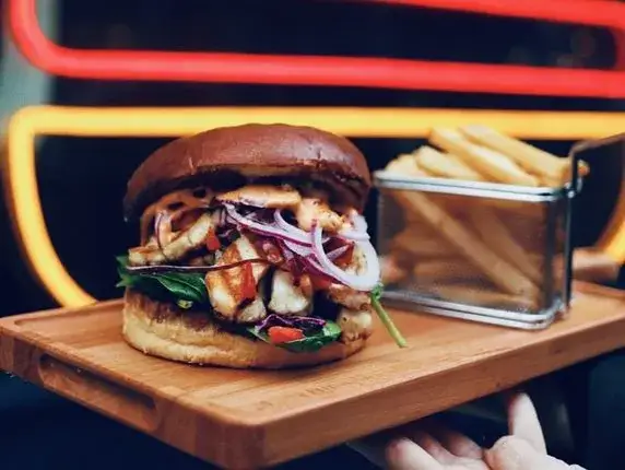 Burger przekrojony na pół na desce do serwowania