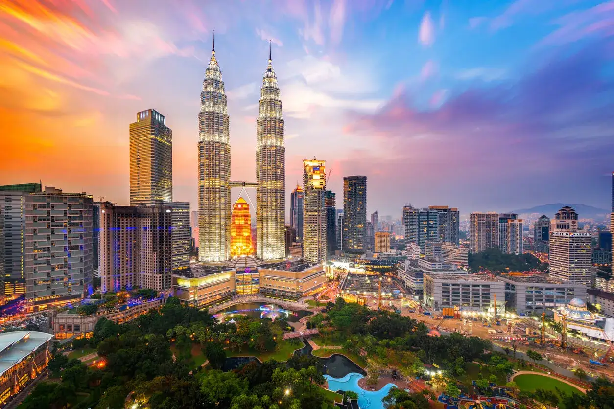 Wieżowce Petronas Towers w Kuala Lumpur o zachodzie słońca. Idealny czas, kiedy najlepiej lecieć do Kuala Lumpur, to okres od czerwca do września.