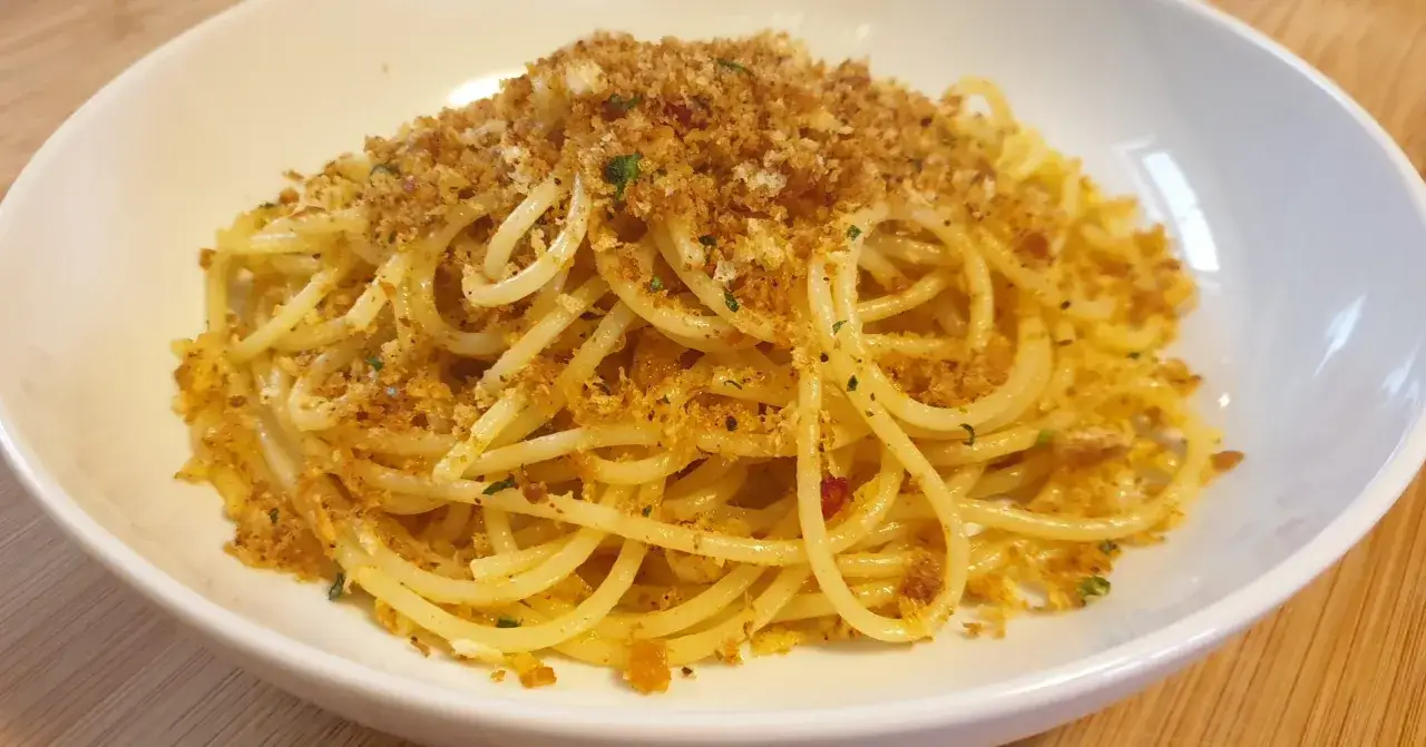 Spaghetti conditi con aglio, olio e abbondante pasta con la mollica croccante, un piatto semplice ma gustoso.