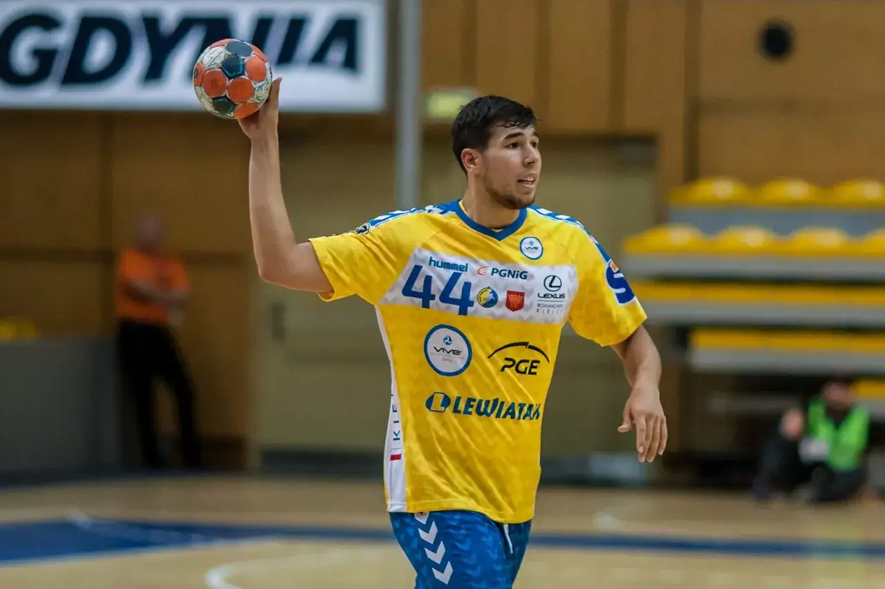 Daniel Dujshebaev w ż&oacute;łtej koszulce z numerem 44, gotowy do rzutu piłką ręczną.