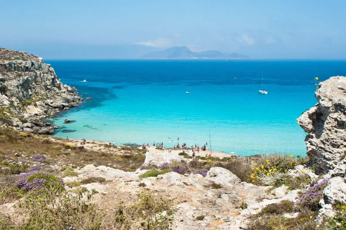 Splendide calette di Favignana con acque cristalline e gente che si gode il sole.