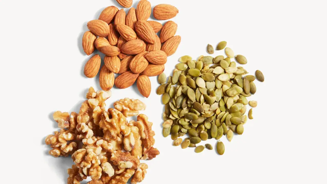 En hög med mandlar, valnötter och pumpafrön. Dessa nötter och frön är utmärkta källor till mat och magnesium.