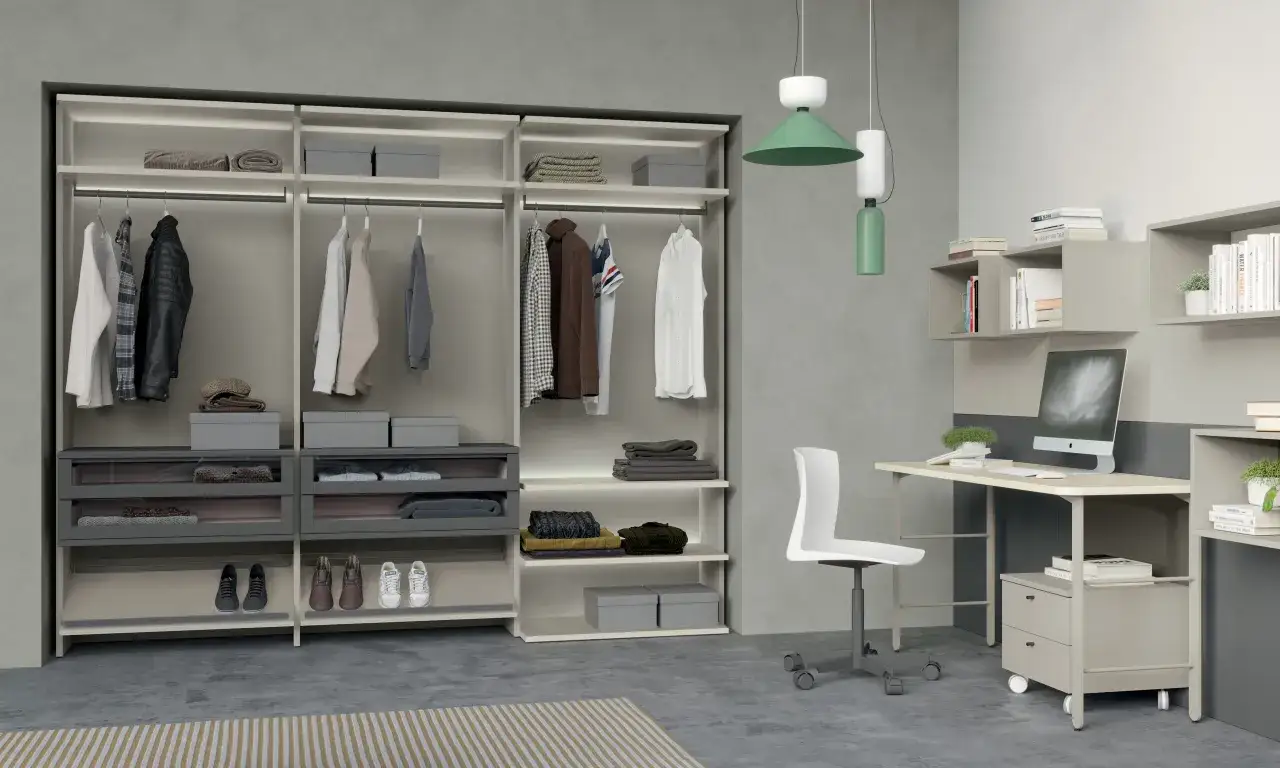 Armadio a giorno con abiti ordinati, scarpe e accessori. Scrivania con computer e sedia, in una moderna camera da letto senza finestra.