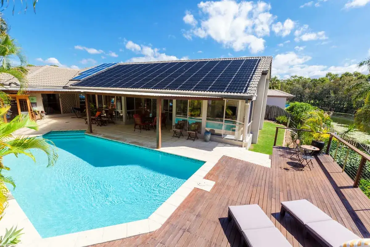 Piscina con paneles solares en el tejado, ideal para saber como calentar el agua de la piscina de forma ecológica.