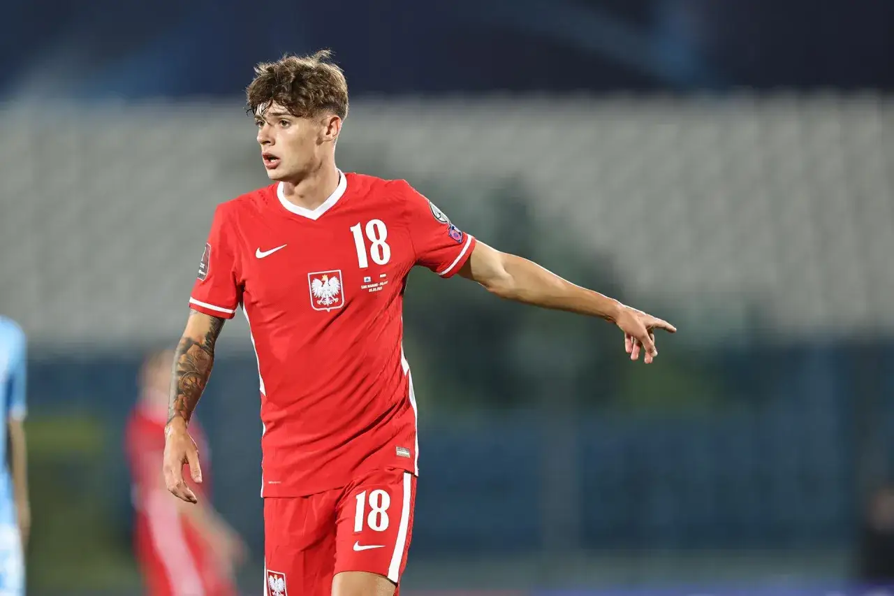 Piłkarz Nicola Zalewski w czerwonej koszulce z numerem 18, wskazujący palcem.