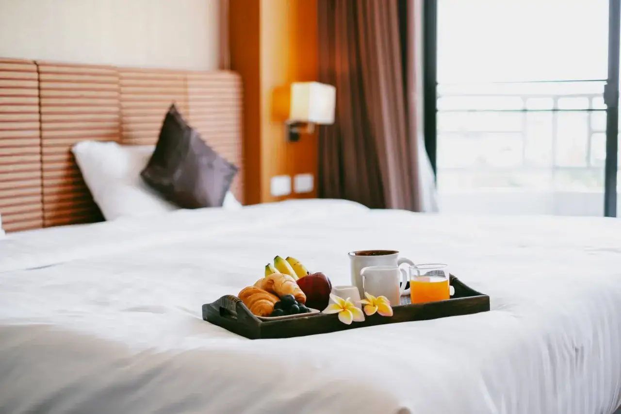 Śniadanie na tacy: rogaliki, owoce, kawa i sok. To część wyposażenia pokoi hotelowych, kt&oacute;re umilają pobyt.