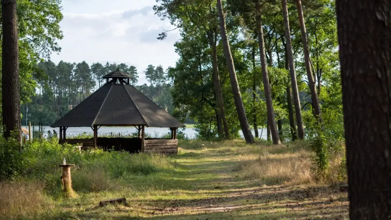 Drewniana altana nad jeziorem, idealne miejsce na letni scout camp Poznań.