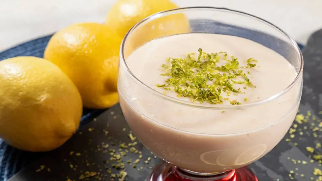 Delicioso mousse de lim&oacute;n thermomix, decorado con ralladura de lim&oacute;n fresco y acompa&ntilde;ado de limones amarillos.