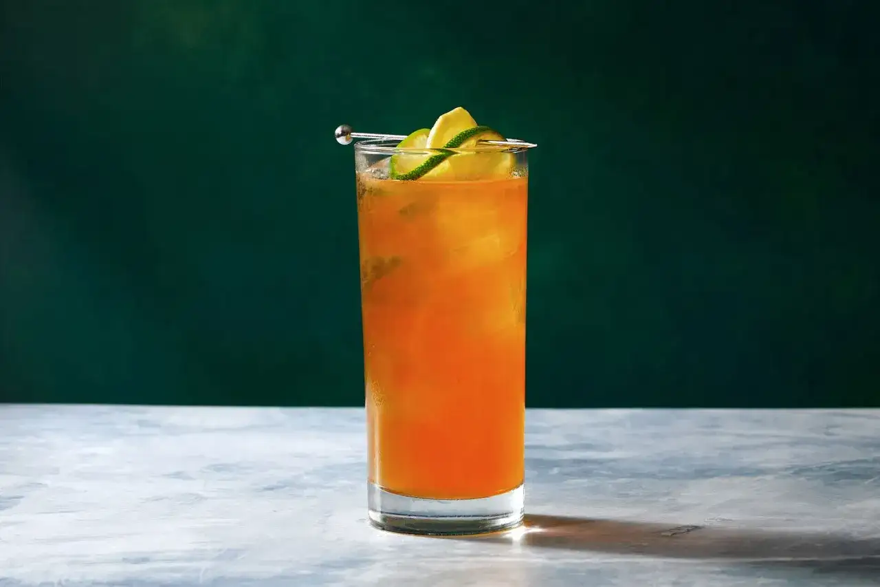 Pomarańczowy drink z lodem i plasterkami limonki, idealny na **dark and stormy** wieczór.