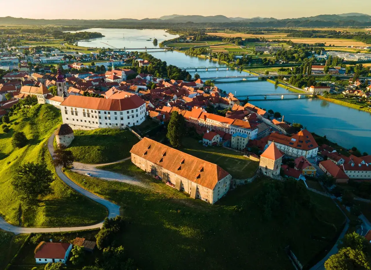 Malownicze miasteczko nad rzeką, idealne na słowenia przewodnik. Zamki, czerwone dachy i zielone wzgórza.
