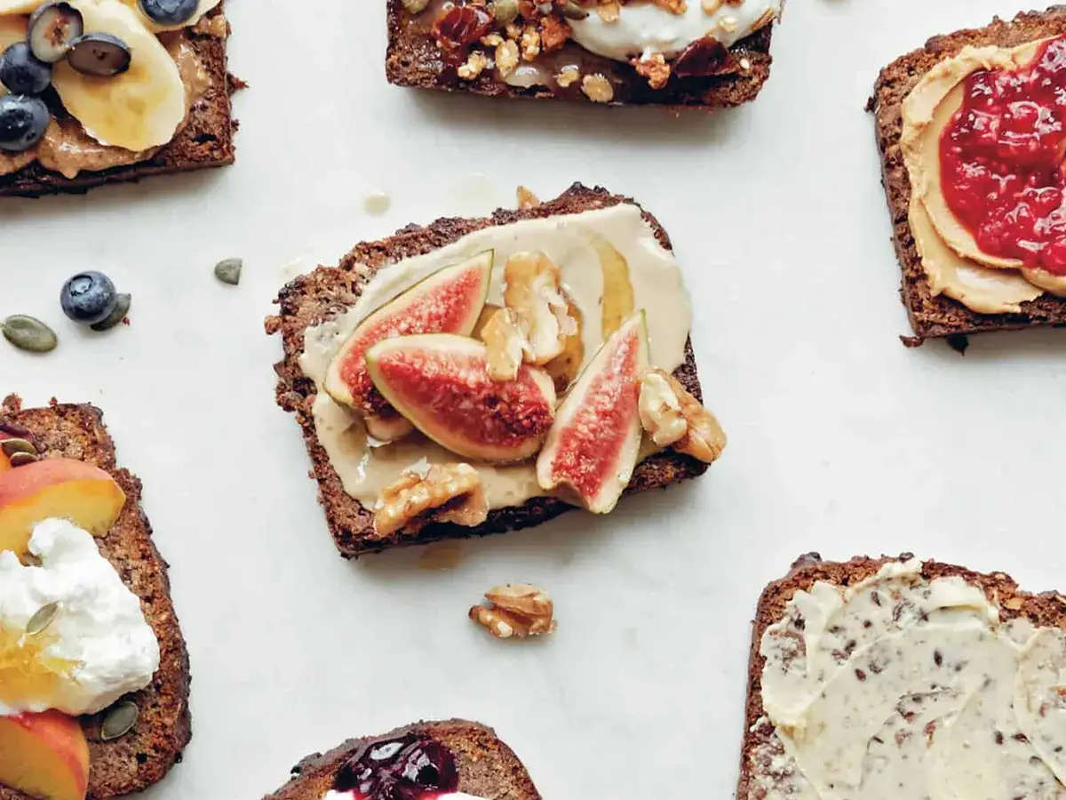 Bananen-Toast mit Feigen, Nüssen und Beeren. Köstliche Scheiben von Bananen-Toast, belegt mit verschiedenen Toppings wie Feigen, Nüssen, Beeren und Marmelade.