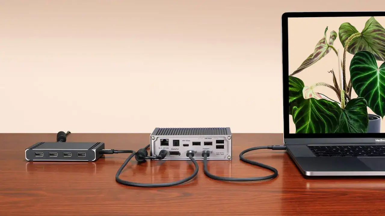 En dockningsstation med thunderbolt 4-portar ansluten till en laptop. En annan hub med USB-portar syns till v&auml;nster.