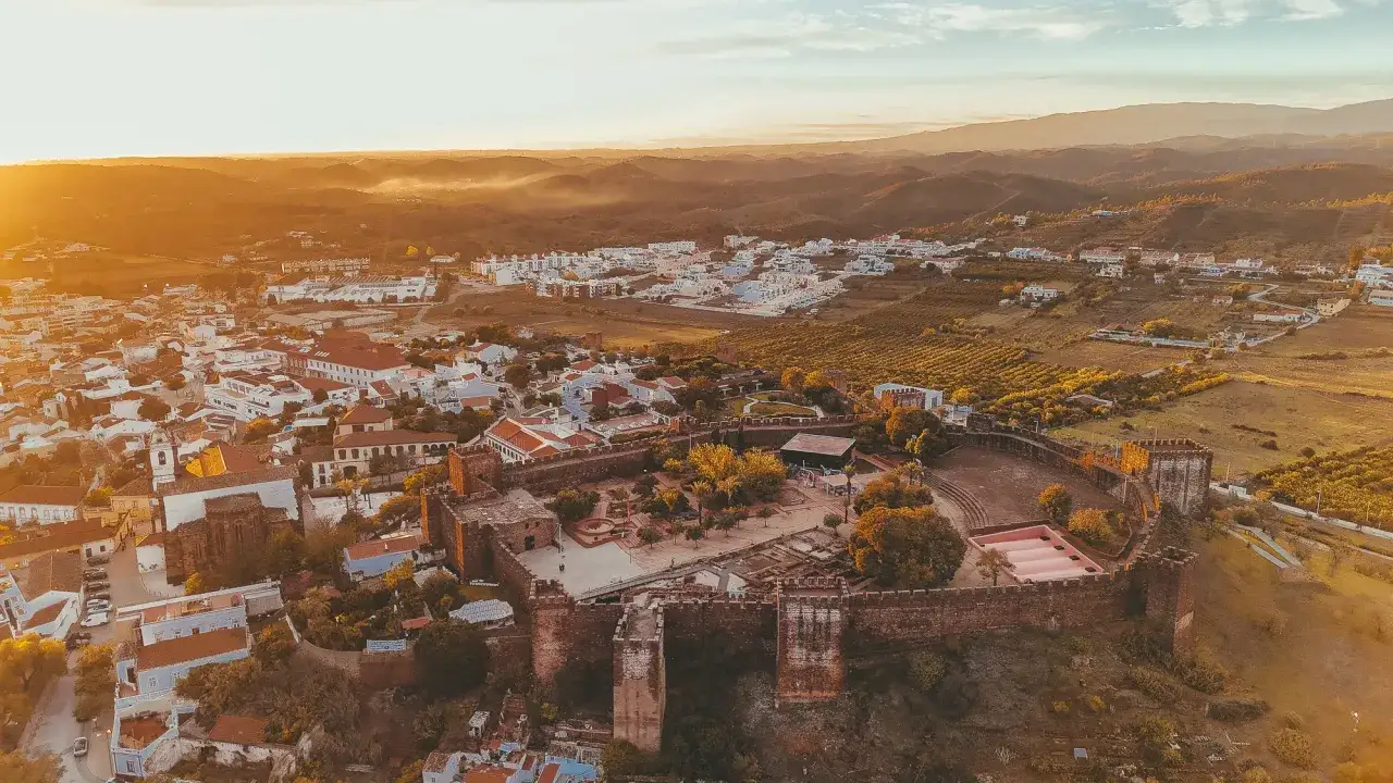 Silves, Portugal: Eine Burg thront über der Stadt im warmen Abendlicht.