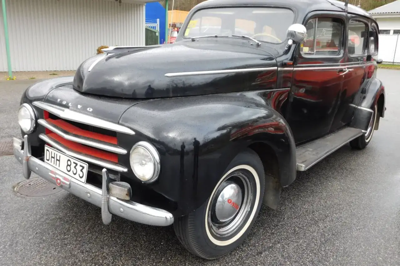 Svart Volvo PV 831, en klassisk bil med kromdetaljer och röda accenter på grillen.