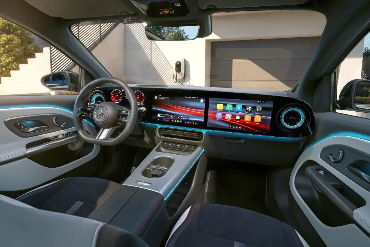 Wnętrze nowoczesnego Mercedesa GLA 200 z dużym ekranem multimedialnym i podświetleniem ambientowym.