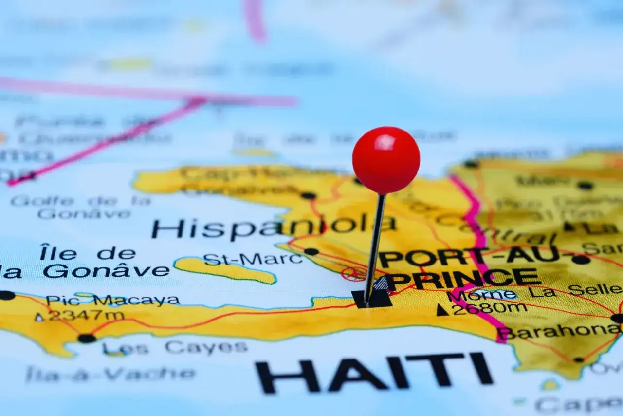 Mapa pokazuje Haiti i państwo sąsiadujące z Haiti, Dominikanę, na wyspie Hispaniola. Czerwony pinezka zaznacza stolicę Haiti, Port-au-Prince.