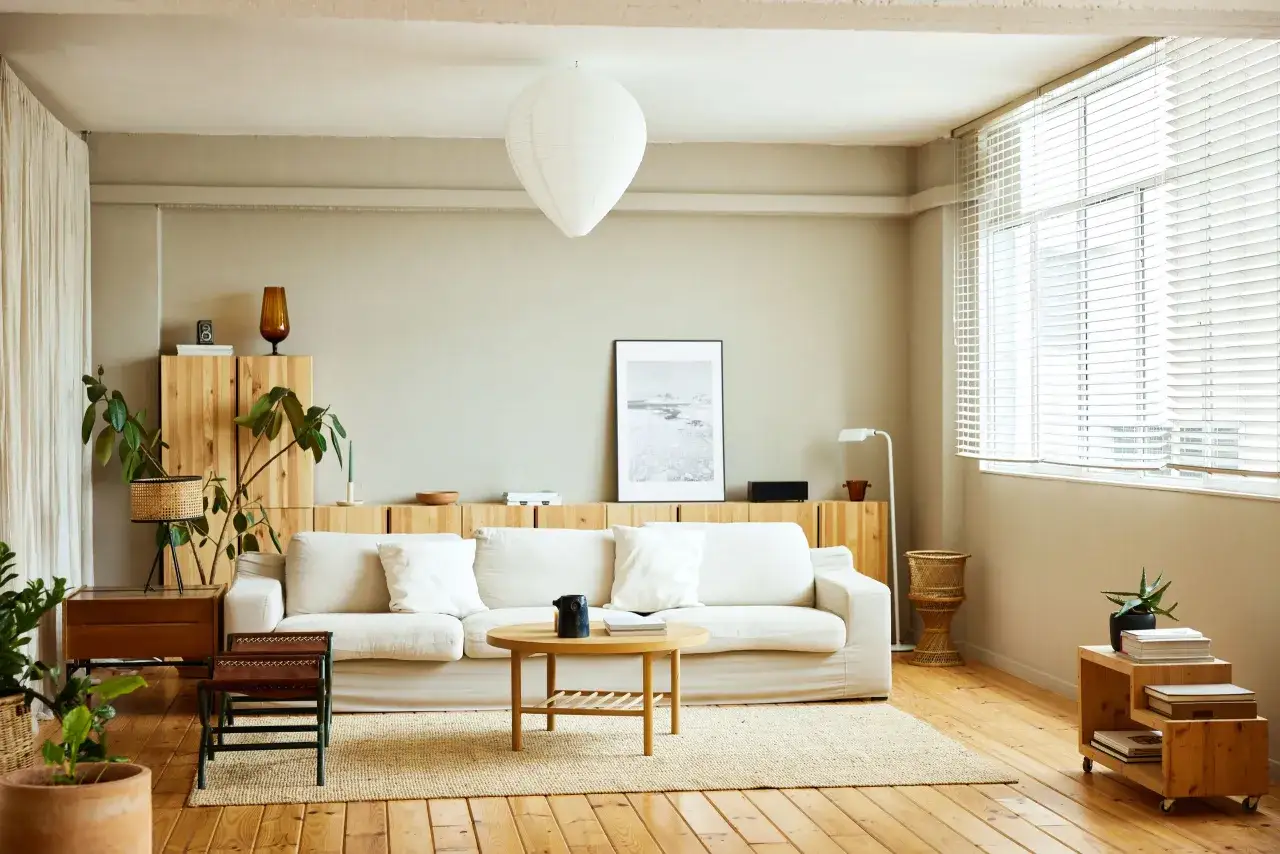 Vardagsrum med vit soffa, tr&auml;inredning och en k&auml;nsla av dansk design inredning.