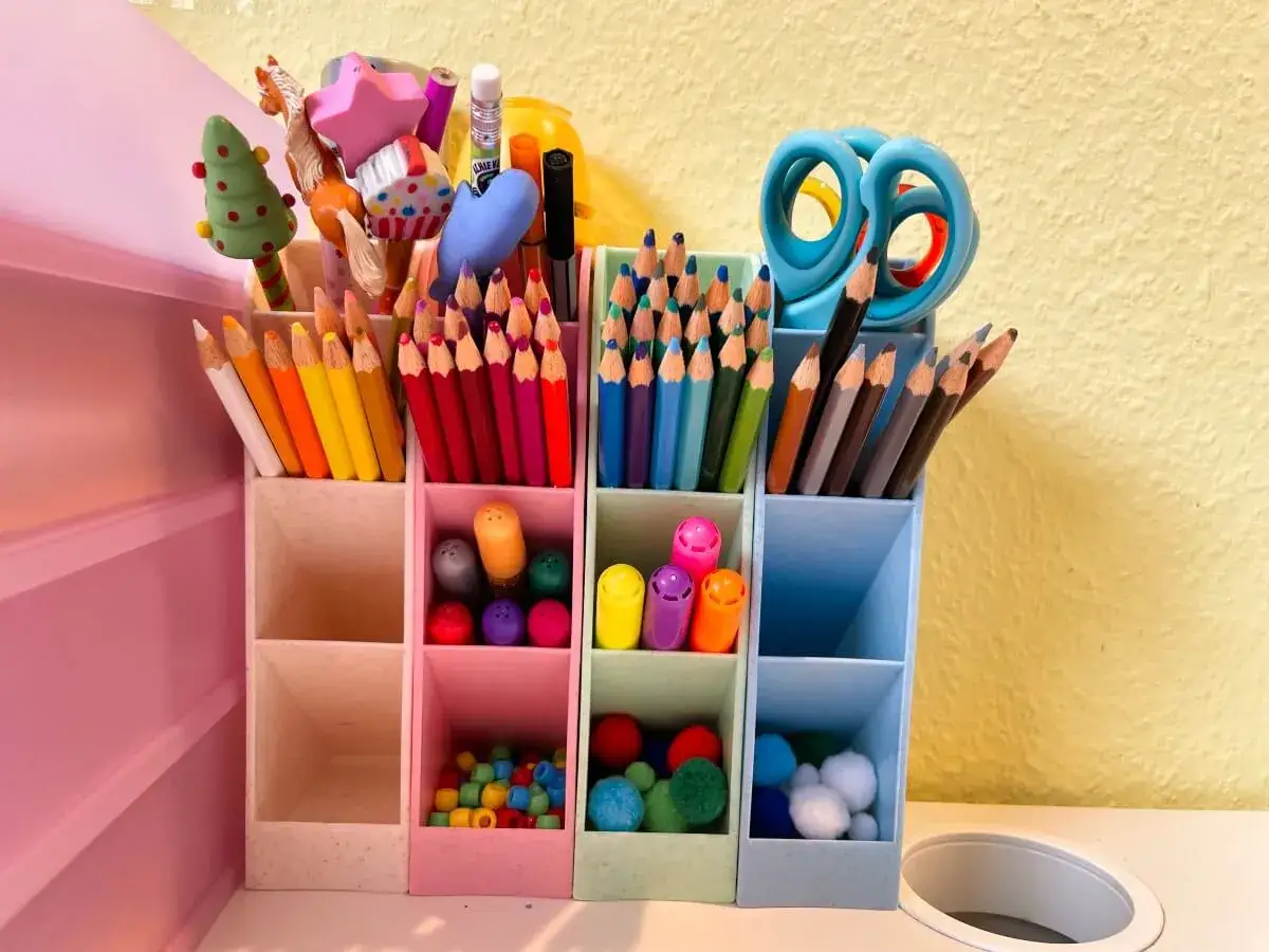 Buntstifte, Scheren und kleine Pompons sind ordentlich in einem Organizer verstaut. So macht das Schulsachen organisieren Spa&szlig;!