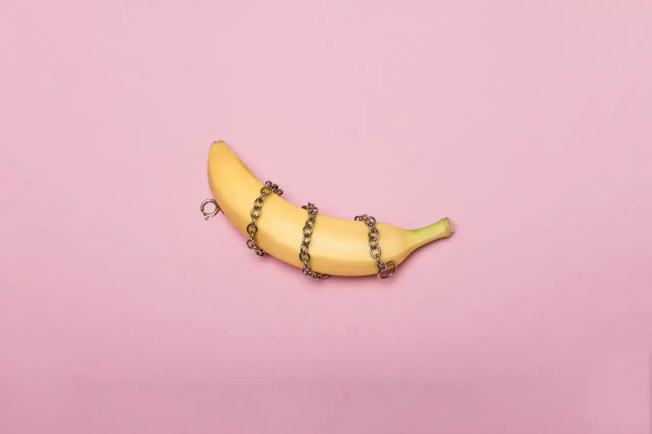 Banan owinięty łańcuchami, sugerujący sesję BDSM.