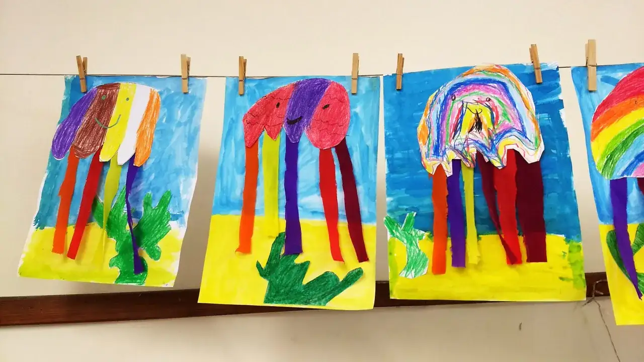 Bunte Quallen-Bilder von Grundsch&uuml;lern h&auml;ngen an einer W&auml;scheleine. Ein **bewertungsbogen kunst grundschule** k&ouml;nnte hierf&uuml;r erstellt werden.