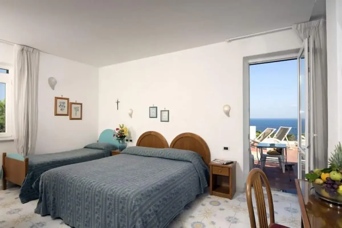 Camera con due letti singoli e un letto matrimoniale all'Hotel Gemma, con vista mare e terrazza.