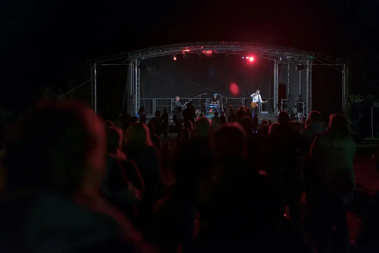 Koncert na jednym z 3 festiwali muzycznych w Polsce i na świecie. Na scenie zespół gra dla publiczności zgromadzonej w ciemności.