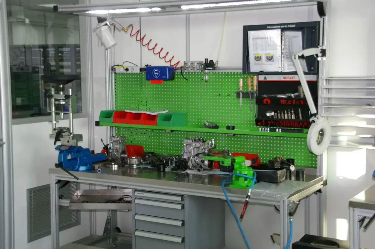 Atelier de réparation d'injecteurs diesel, avec pièces et outils. Le prix de la réparation d'injecteur diesel est affiché sur le tableau d'information.