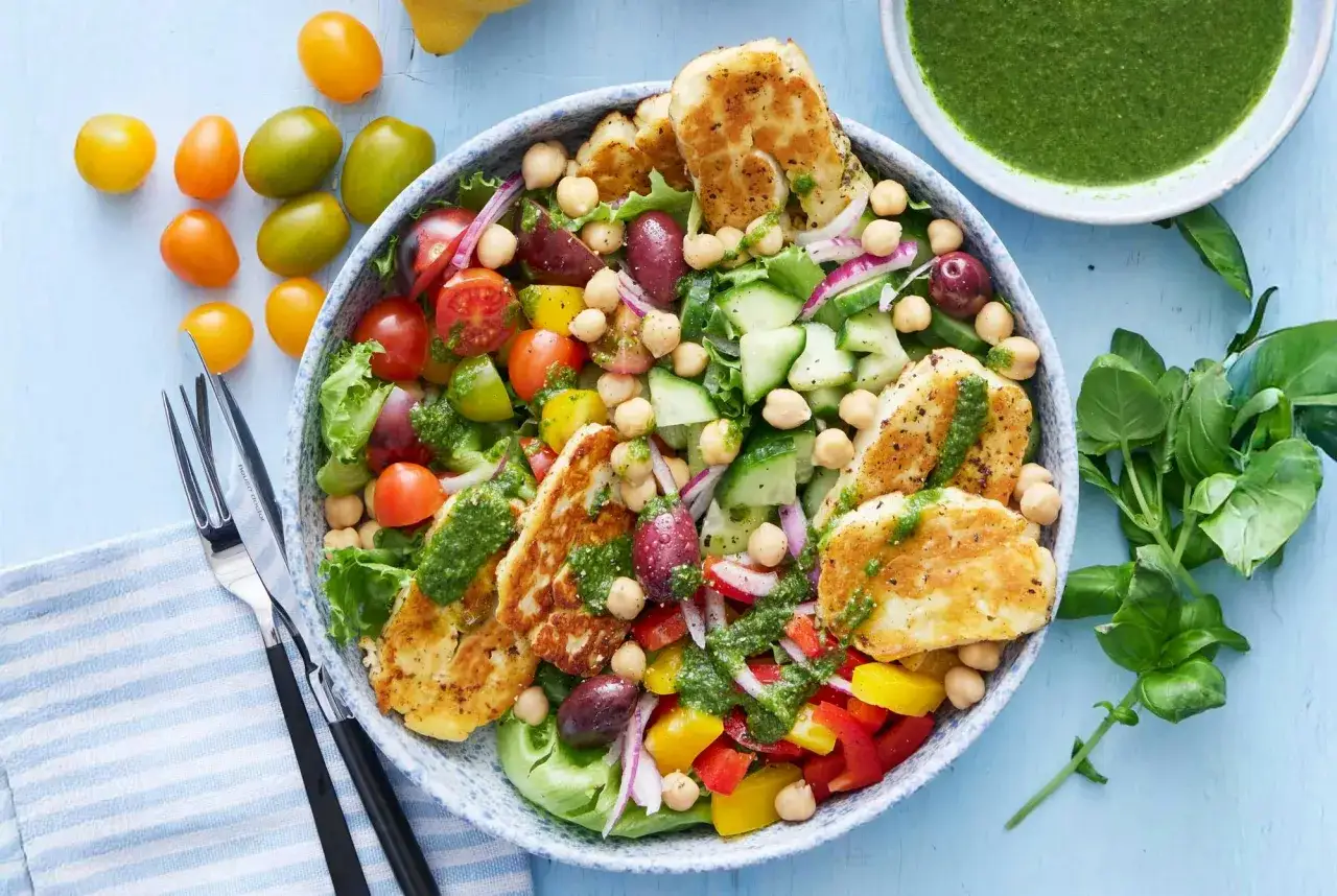 En härlig halloumi sallad med körsbärstomater, gurka, kikärtor, oliver och en grön dressing. Perfekt för en lätt lunch.