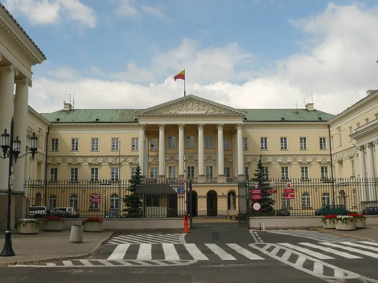 Pałac Saski, siedziba prezydenta Warszawy, z kolumnadą i flagą na dachu.
