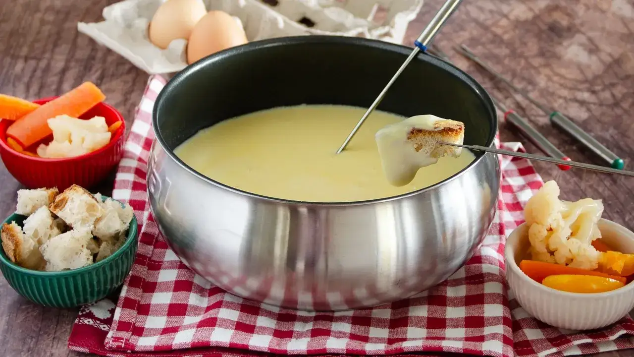 Una calda fonduta valdostana, con pane croccante e verdure, pronta per essere gustata.