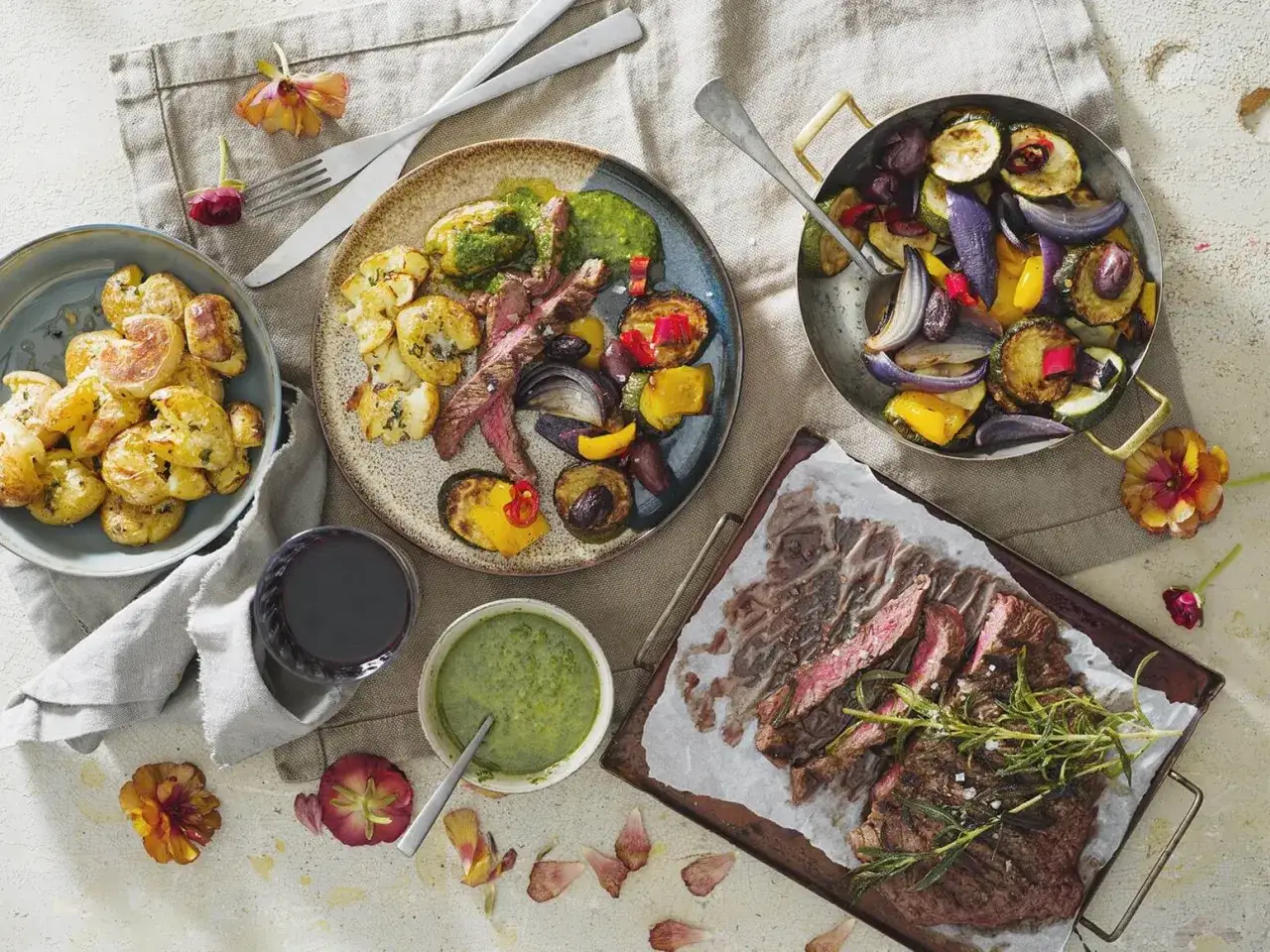 En saftig flankstek marinad serveras med rostade grönsaker och krispiga potatisar. En grön sås fulländar denna läckra måltid.