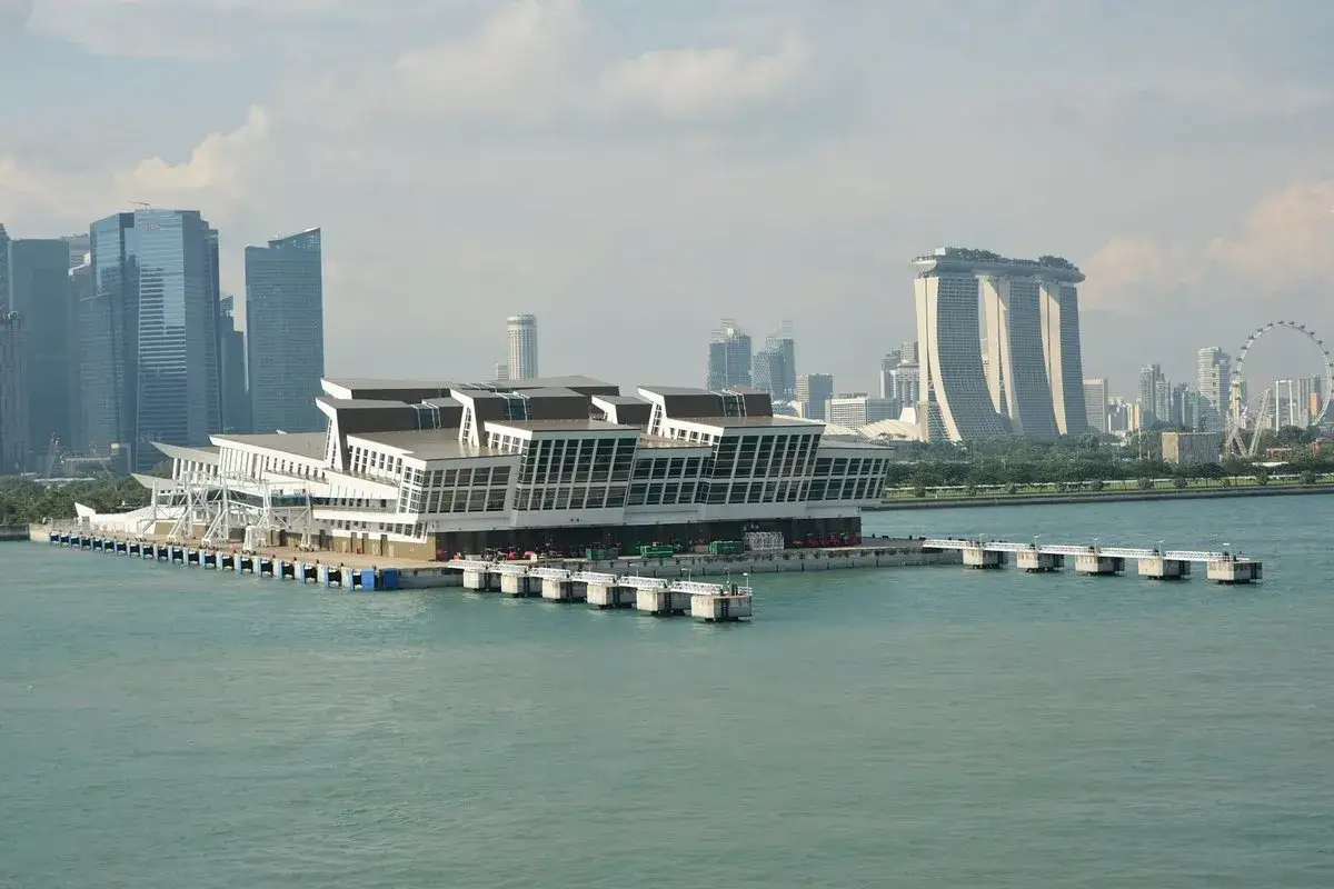 Moderno terminal crociere galleggiante nel **singapore porto**, con grattacieli iconici sullo sfondo.