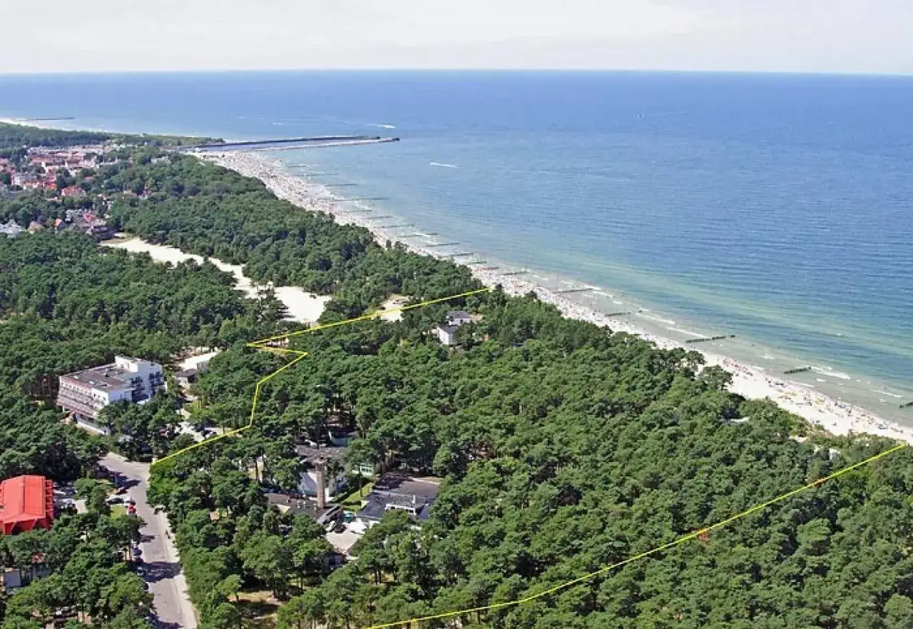 Widok lotniczy na wybrzeże Bałtyku w Ustce. Widać plażę, morze, las sosnowy i zabudowania. Sprawdź albatros ustka cennik.