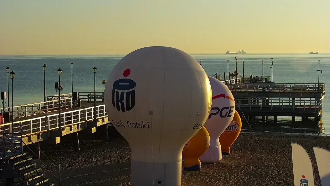 Balony reklamowe na plaży w Brzeźnie, z widokiem na molo i morze.
